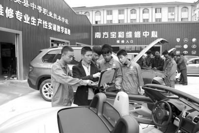大英縣中等職業學校通過“引企入?！?，將企業維修中心建到了校園內，圖為企業專業技師向學生講解高檔轎車的保養維修技巧。